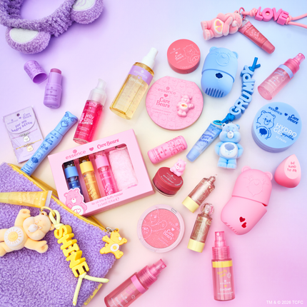 essence x Care Bears make up collectie met blush, oogschaduw, lipolie en accessoires op paarse en roze achtergrond