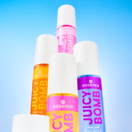 Essence Juicy Bomb Mood Boosting Drop body mists in oranje, roze en paars tegen een blauwe lucht